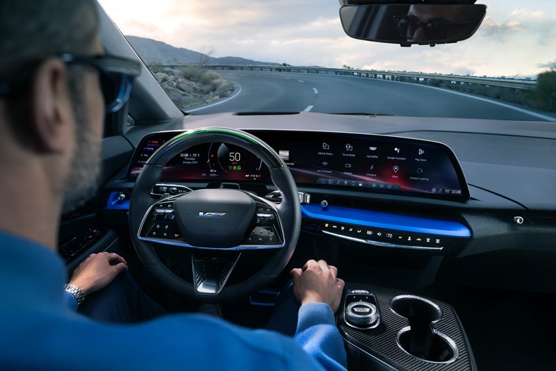 Front View of the 2026 OPTIQ-V Driving Through the Dusk Utilizing its Headlights | Springfield Cadillac in N. Springfield VT